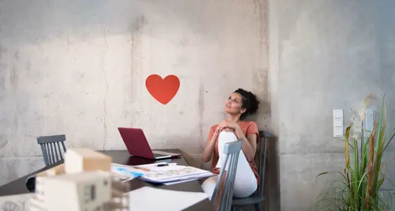 Woman working at a table looking at a heart