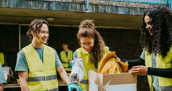 Group of volunteers sorting through donated clothes