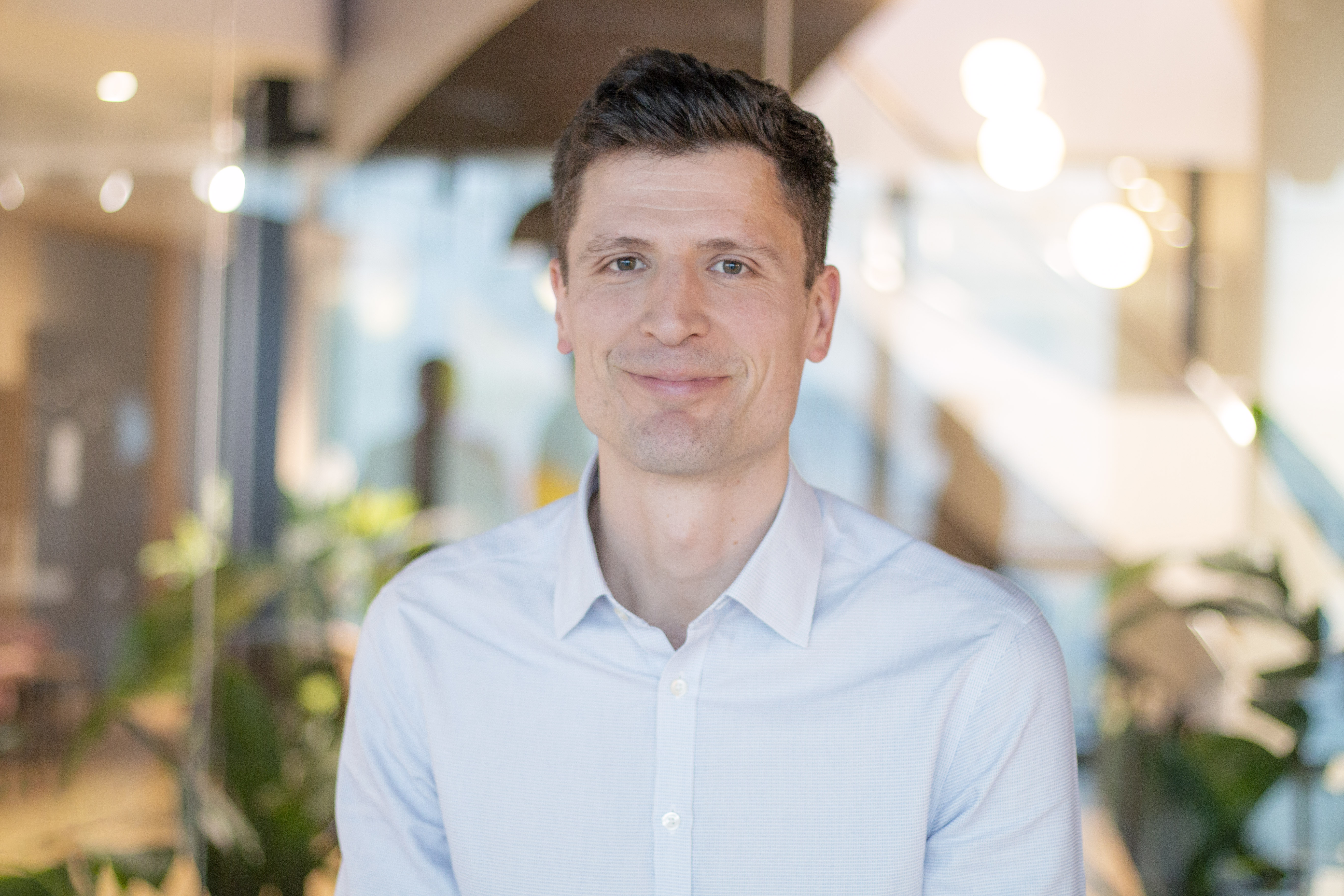 A professional headshot of Adam Burden