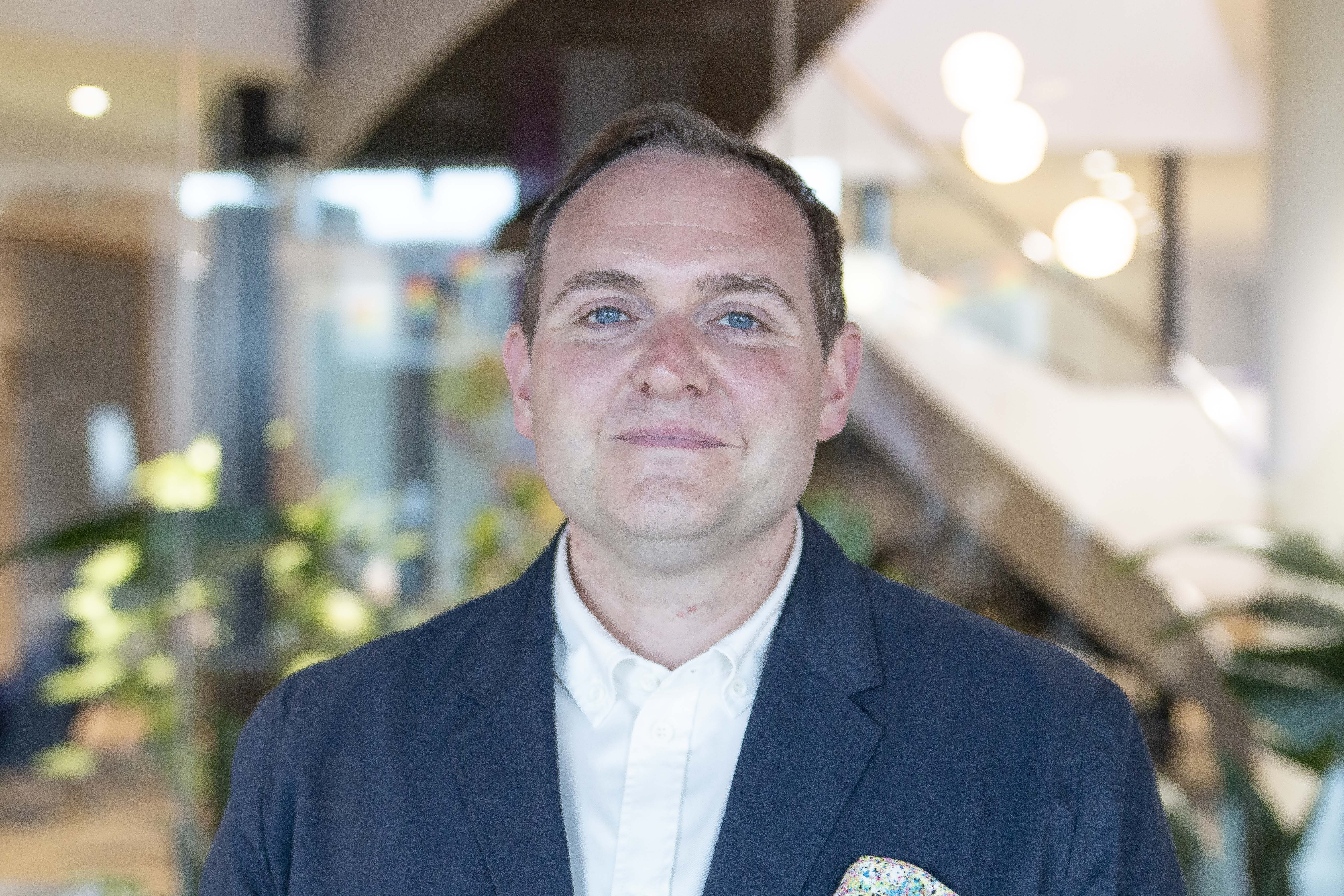 A professional headshot of Nick Varney