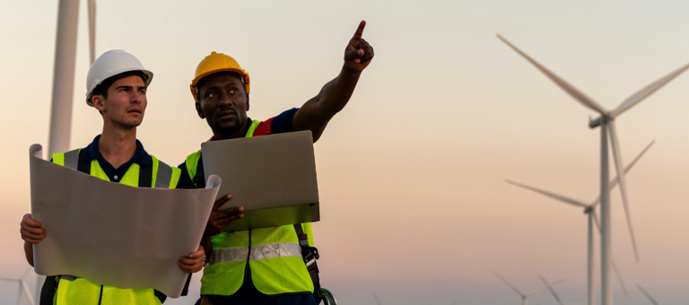 Two workers inspecting a wind farm