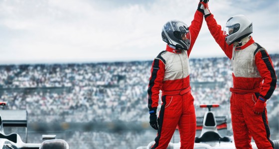 Two drivers high fiving on race course