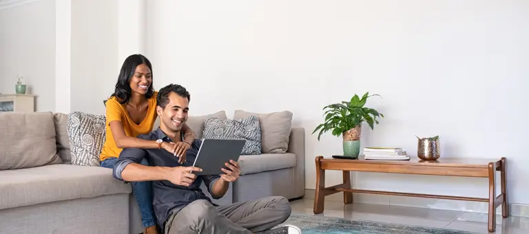 Couple sitting on couch looking at tablet