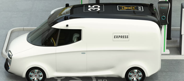 A white electric van at a charging station