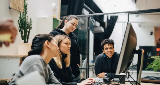 Four analysts looking at a computer screen