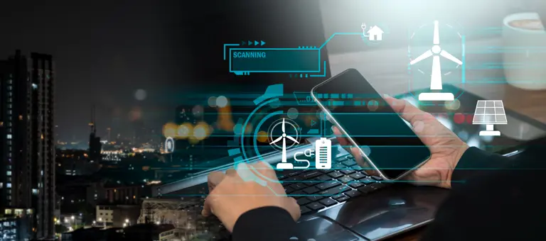 Hands holding a smartphone while typing on a keyboard