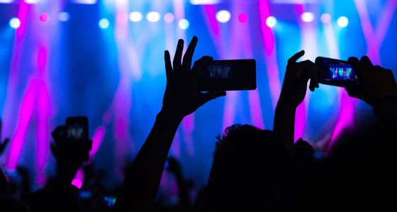 People filming with their smartphones at a concert