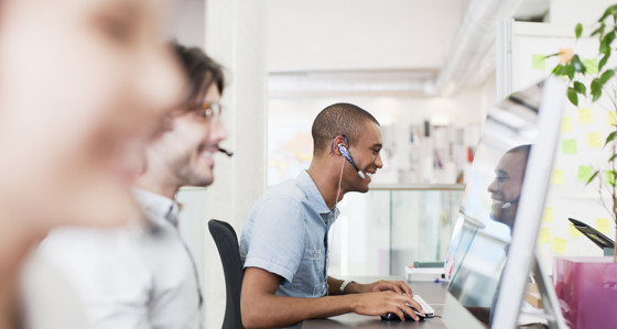 Smiling people wearing headsets working in a call center