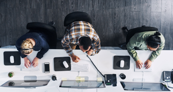 Three people seen from above working on their desks