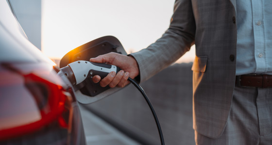 A man charging an electric vehicle