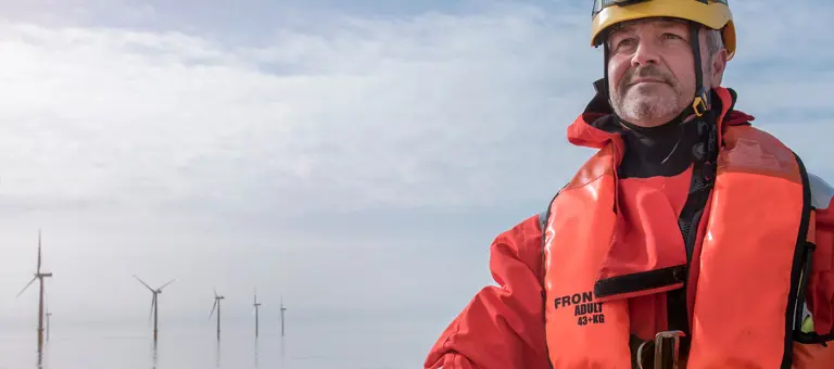 An engineer in front of an offshore windfarm