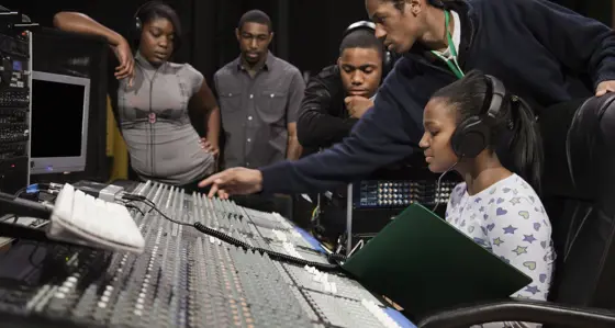A woman sitting at a recording studio mixing desk