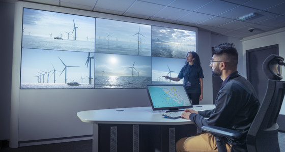Male and female operators in offshore wind farm control room 