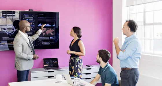 Businessman using graphs on screen in business meeting