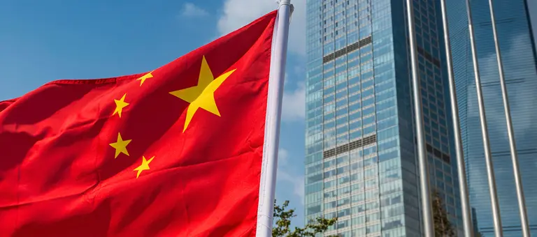 China Flag flying in front of skyscrapers