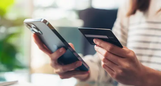 A person using a phone and payment card