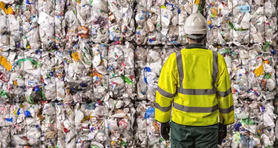 Worker looking at piles of plastic