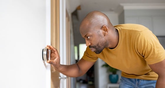 Man adjusting a thermostat