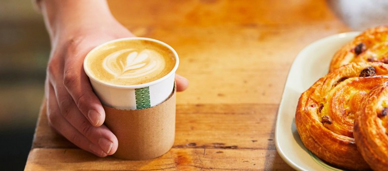 Close up of man's hand serving a coffee at a coffee shop