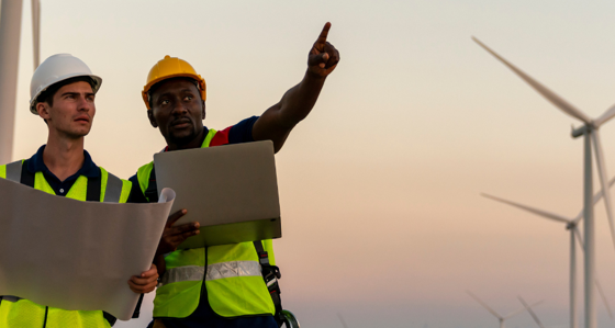 Two workers inspecting a wind farm