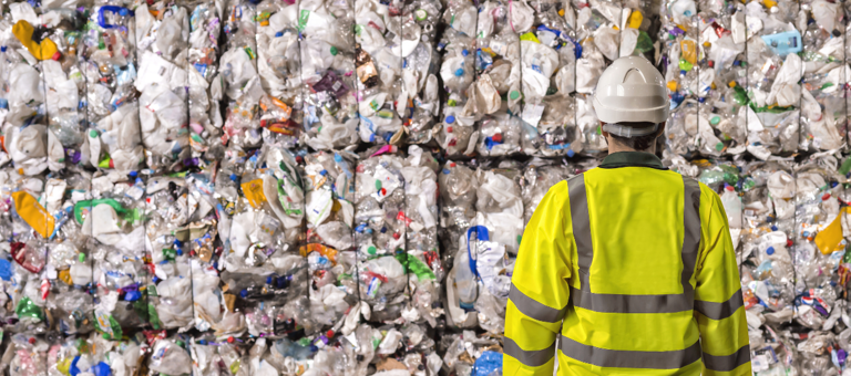Worker looking at piles of plastic