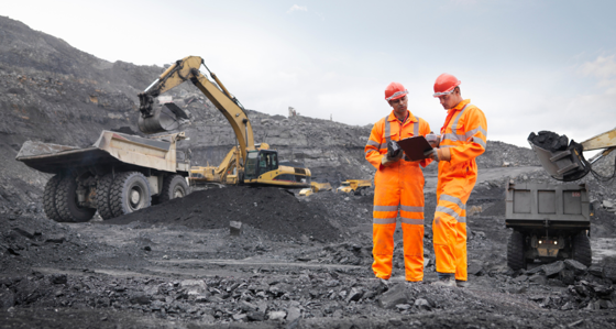 Two mine workers looking at a clipboard