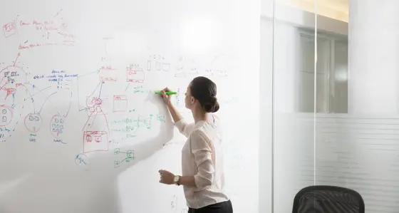 A woman writing on a whiteboard