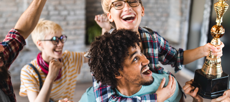 A group of people celebrating holding an award