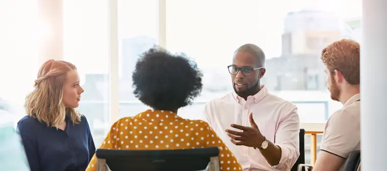 Four people having a discussion in an office