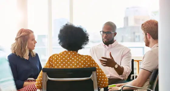 Four people having a discussion in an office