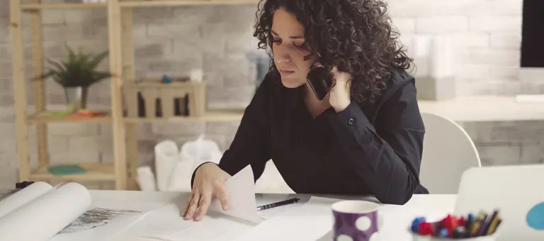 A woman on the phone at her desk