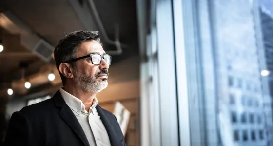 business man looking out of window at city
