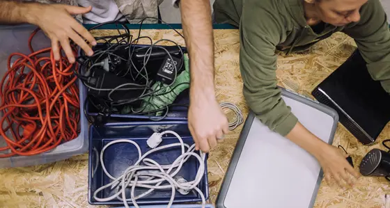 Group of people sorting through e-waste