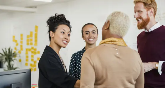 A group of people having a conversation in an office setting