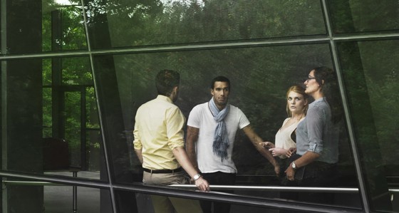 A group of people in a modern building in a green natural setting