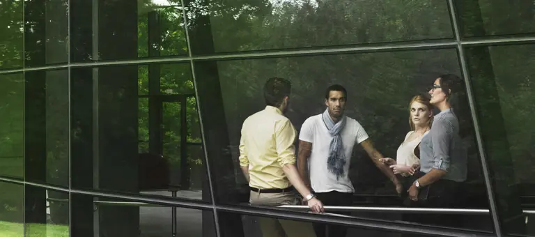 A group of people in a modern building in a green natural setting