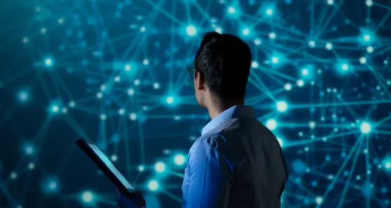 IT Specialist using tablet computer in front of big screen