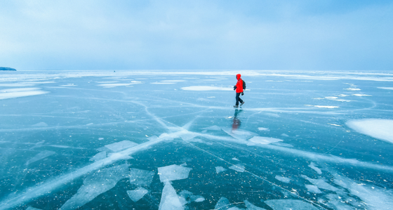 Man walking across frozen lake