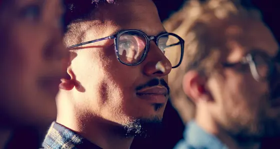 Man with glasses looking into the distance