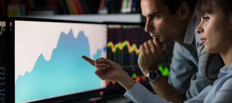 Two people looking at data on a computer screen