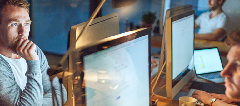 A man deep in thought while looking at a computer