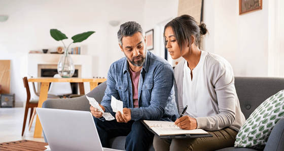 A woman and a man looking at receipts and bills