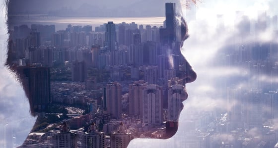 Man's head superimposed over a cityscape in clouds