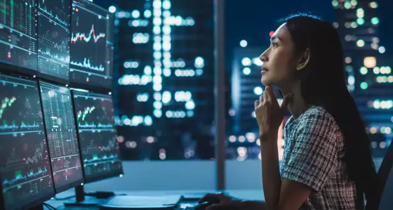 A woman looking at data on multiple screens