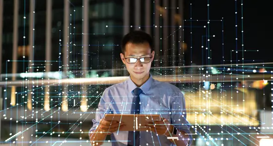 Businessman looking at ipad surrounded by lines representing payments architecture