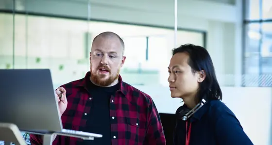 Two colleagues looking at a screen and having a discussion