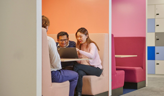 A Baringa team sitting in a meeting both with laptop