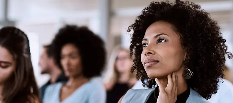 A woman with afro hair listening to a presentation
