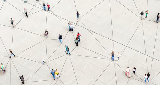 An aerial view of people walking over a triangular-patterned surface