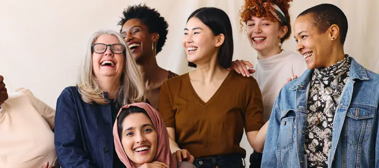 A diverse group of women laughing and smiling